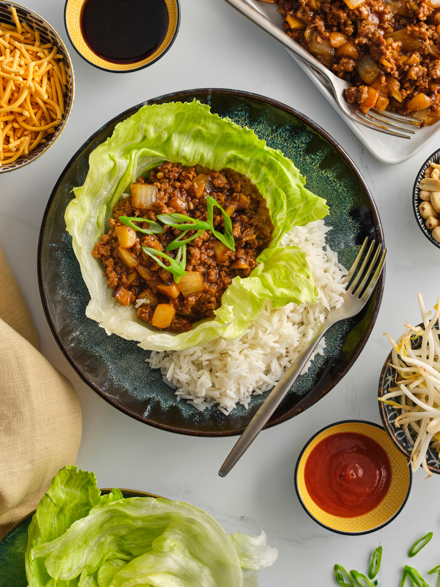 A thick cut veal loin chop resting on a pan of sauteed mushrooms.